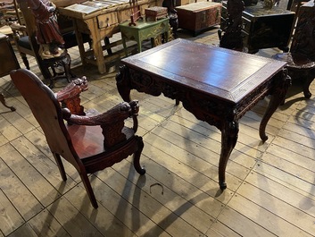 A finely carved Japanese red patinated wooden desk with armchair, 20th C.