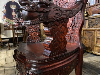 A finely carved Japanese red patinated wooden desk with armchair, 20th C.