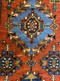 A long Oriental woolen runner with geometric motifs and floral design, 20th C.