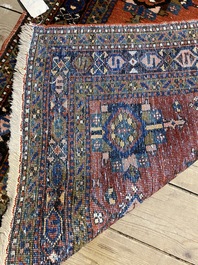 A long Oriental woolen runner with geometric motifs and floral design, 20th C.