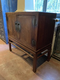 A Chinese hardwooden brass mounted two-door cabinet on foot, 20th C.