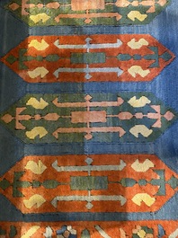 An Oriental woolen rug with floral design and geometric motifs, 20th C.