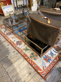 An Oriental woolen rug with floral design and geometric motifs, 20th C.