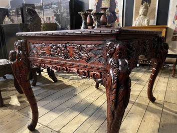 A finely carved Japanese red patinated wooden desk with armchair, 20th C.