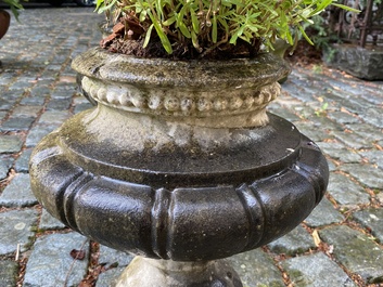 A pair of stone garden vases on square bases, one dated 1873