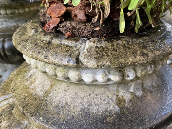 A pair of stone garden vases on square bases, one dated 1873