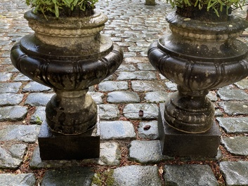 A pair of stone garden vases on square bases, one dated 1873