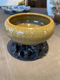 A Chinese crackle-glazed tripod censer on carved wooden stand, 19th C.