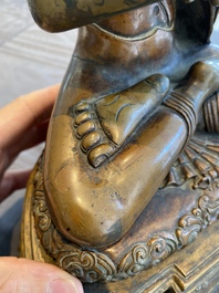 A large Tibetan brass and copper Buddha on throne, probably 16th C.