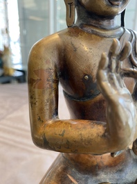 A large Tibetan brass and copper Buddha on throne, probably 16th C.