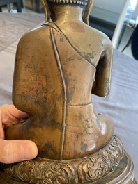 A large Tibetan brass and copper Buddha on throne, probably 16th C.