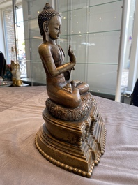 A large Tibetan brass and copper Buddha on throne, probably 16th C.