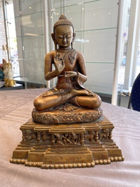 A large Tibetan brass and copper Buddha on throne, probably 16th C.