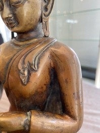 A large Tibetan brass and copper Buddha on throne, probably 16th C.