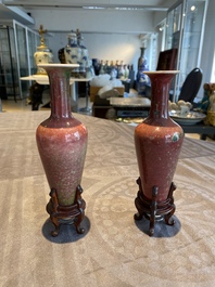 A pair of Chinese peachbloom-glazed vases on wooden stands, Kangxi mark, 19th C.