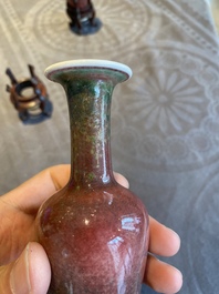 A pair of Chinese peachbloom-glazed vases on wooden stands, Kangxi mark, 19th C.