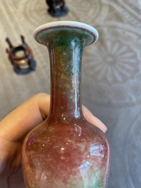 A pair of Chinese peachbloom-glazed vases on wooden stands, Kangxi mark, 19th C.