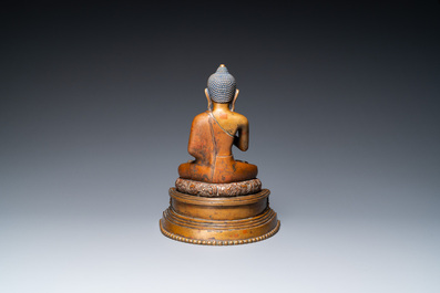 A large Tibetan brass and copper Buddha on throne, probably 16th C.