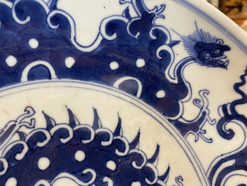 A Chinese blue and white 'dragon' dish and three iron-red and famille rose plates, 18th C.