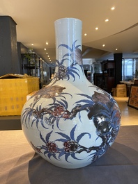 A Chinese blue, white and copper-red 'nine peaches' bottle vase, Guangxu mark and of the period