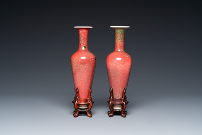 A pair of Chinese peachbloom-glazed vases on wooden stands, Kangxi mark, 19th C.