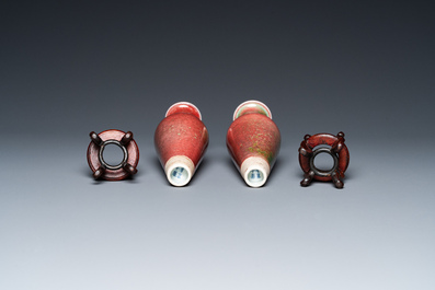 A pair of Chinese peachbloom-glazed vases on wooden stands, Kangxi mark, 19th C.