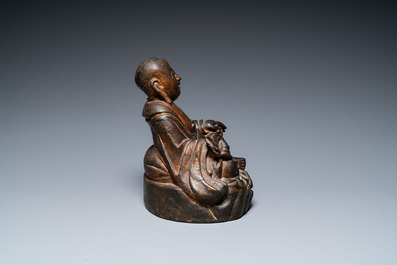 A Chinese gilt bronze figure of Buddha seated on a rock, Ming