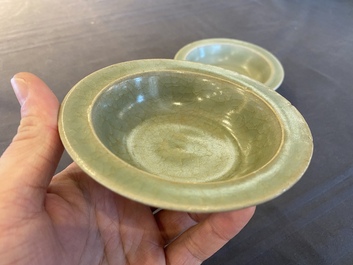Two Chinese celadon-glazed bowls, one with twin fish, Ming