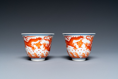 A pair of Chinese iron-red-decorated 'dragon' cups and a yellow-ground 'dragon' saucer, 19/20th C.