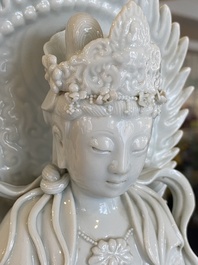 Een Chinese blanc de Chine sculptuur van Guanyin op een lotustroon, 19/20e eeuw