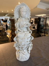 Een Chinese blanc de Chine sculptuur van Guanyin op een lotustroon, 19/20e eeuw