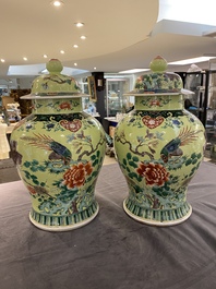 A pair of Chinese famille verte yellow-ground vases and covers, 19th C.