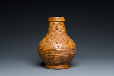 A rare German stoneware bellarmine jug with a bearded face sticking his tongue out, Cologne, 16th C.