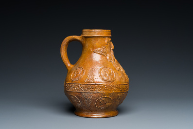 A rare German stoneware bellarmine jug with a bearded face sticking his tongue out, Cologne, 16th C.