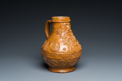 A rare German stoneware bellarmine jug with a bearded face sticking his tongue out, Cologne, 16th C.