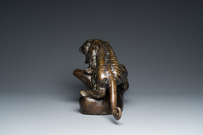A large Vietnamese bronze tiger on a carved wooden stand, 19/20th C.
