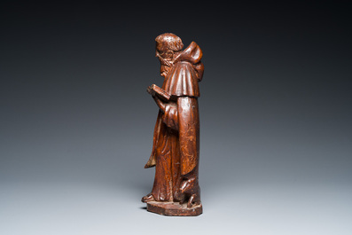A carved oak group of the reading Saint Anthony with a pig, 17th C.
