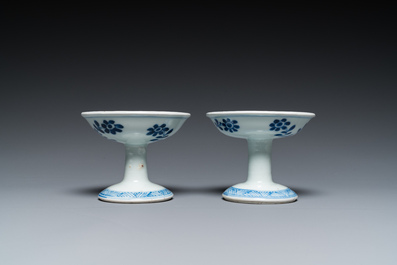 A pair of Chinese blue and white 'lotus scroll' stem cups, Kangxi