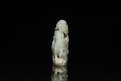A Chinese celadon and russet jade ram sculpture on wooden stand, 19th C.