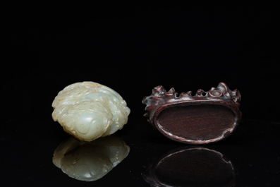 A Chinese celadon and russet jade ram sculpture on wooden stand, 19th C.