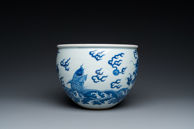 A Chinese blue and white 'dragons and carps' jardini&egrave;re on wooden stand, 19/20th C.