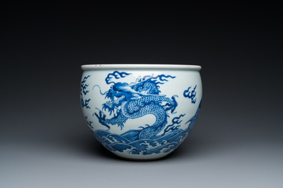 A Chinese blue and white 'dragons and carps' jardini&egrave;re on wooden stand, 19/20th C.