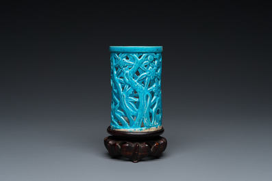 Een Chinese opengewerkte monochrome turquoise penselenbeker op houten voet, Qing