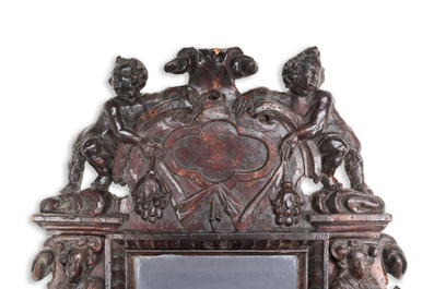 A carved oak mirror with cherubs and caryatids, the Low Countries, 17th C.