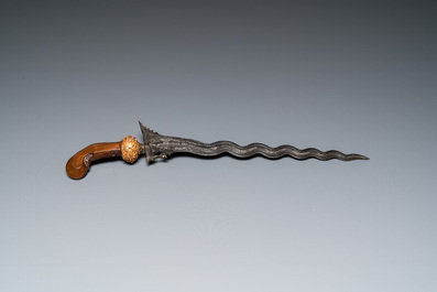 An Indonesian 'kris' or 'keris' dagger in polished Javanese wood with gilt copper and precious stones, 19th C.