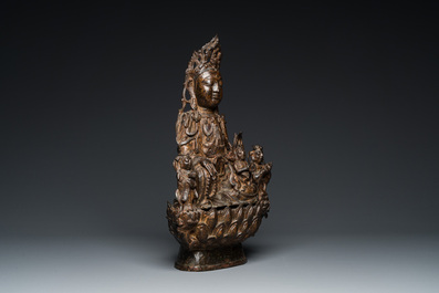 Een grote Chinese vergulde bronzen Guanyin met dienaars, Ming