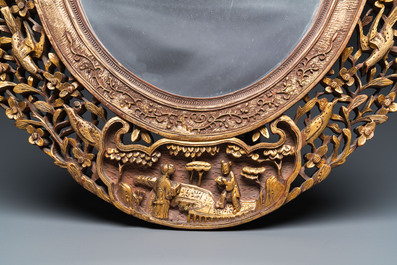 An oval Chinese reticulated gilded wooden mirror, 19/20th C.