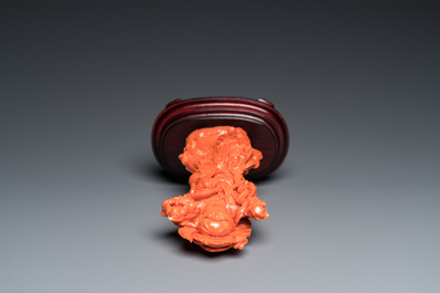 A Chinese red coral carving of Guanyin standing on a lotus throne, 19th C.