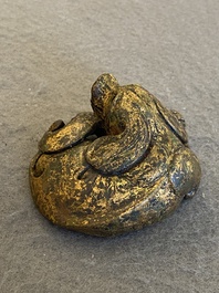 A Chinese gilt bronze &lsquo;dog&rsquo; scroll weight, Ming