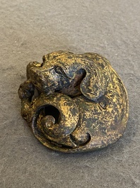 A Chinese gilt bronze &lsquo;dog&rsquo; scroll weight, Ming